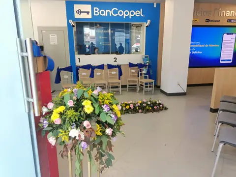 Sucursal BanCoppel: entrada con arreglo floral frente a las ventanillas