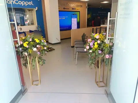 Sucursal BanCoppel: acceso de cristal con arreglos florales