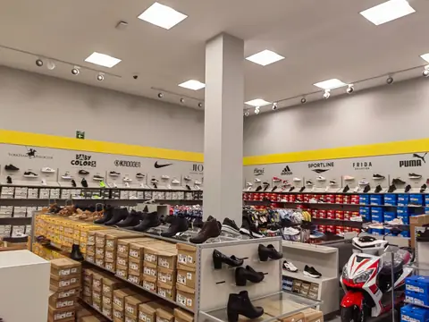 Piso de ventas: columna central, exhibición de calzado y una motocicleta al fondo