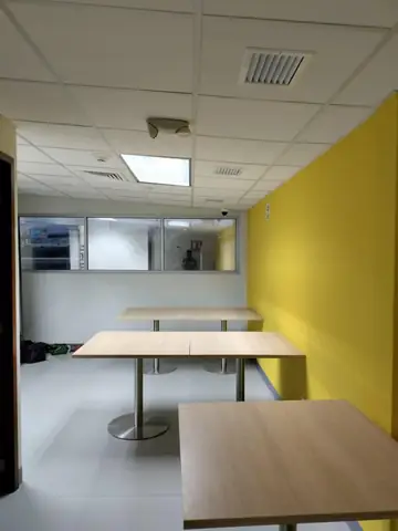 Comedor con muro amarillo y mesas