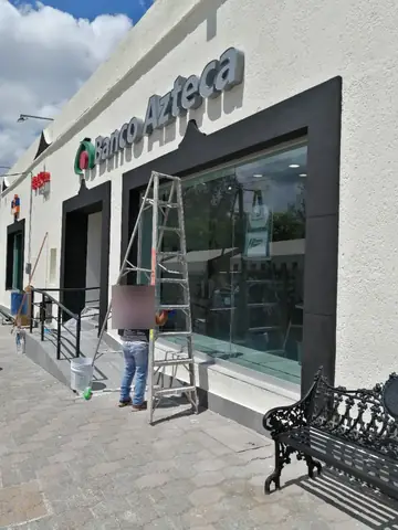 Fachada de sucursal Banco Azteca con marco oscuro y ventanal
