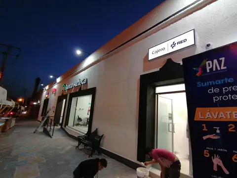 Fachada de noche con rótulo Banco Azteca y cajero Red