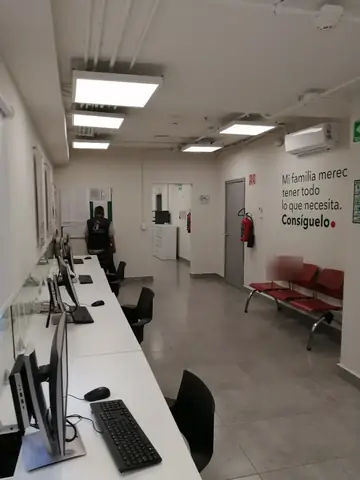 Área de atención con escritorios y sillas rojas