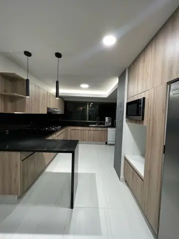 Cocina terminada: barra negra con luminarias colgantes