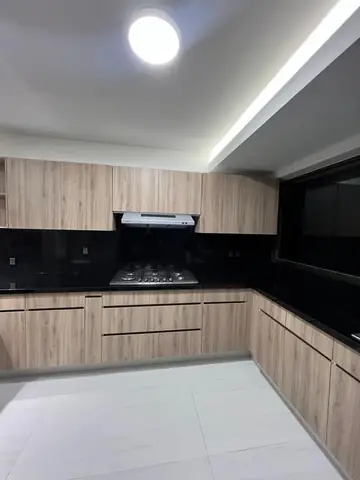 Cocina terminada: campana, parrilla y gabinetes de madera en esquina