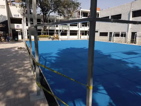 Cancha de piso azul terminado, con cinta de seguridad